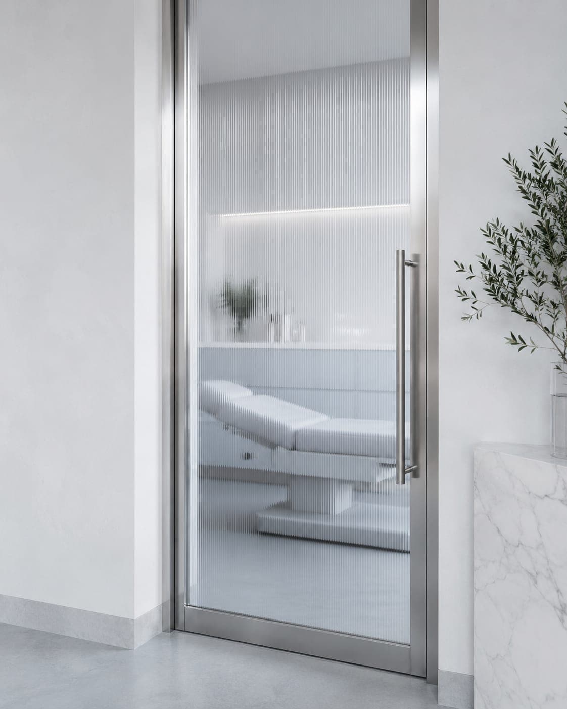 A steel-framed glass door standing open onto a Lumière Dental treatment room, the chair and an olive tree beyond it