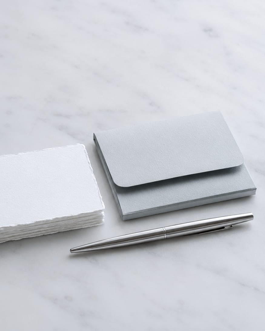 Lumière Dental appointment cards, a folder and a pen laid out on white marble