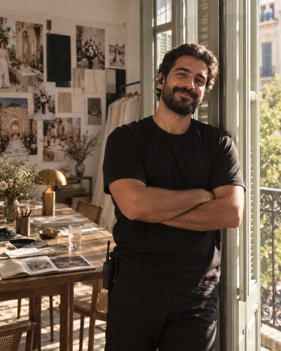Charbel leaning against the shuttered window, arms crossed